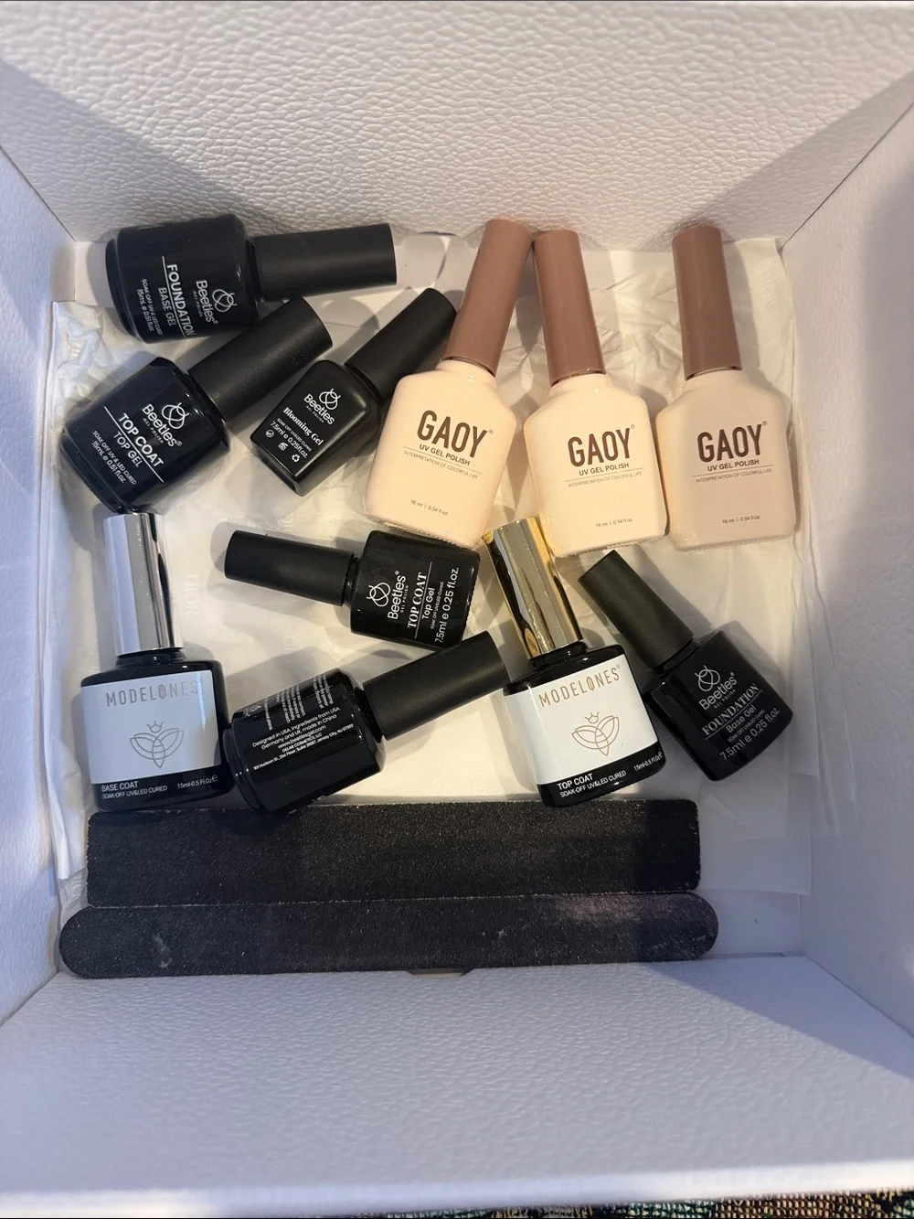 Collection of gel, nail polishes. Mostly light neutrals and dark neutrals.